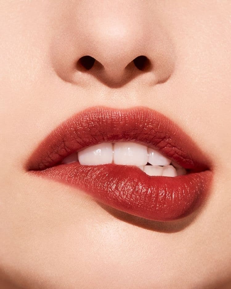 Lady biting lips wearing red lipstick